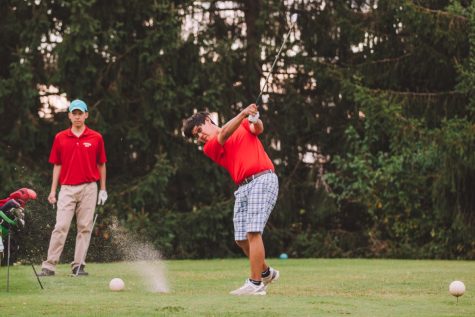 Senior Min Kang takes a swing and senior Richard Pan waits behind him for his turn at the tee during golf senior night on Sept. 14.  Kang has played golf for Jefferson since freshman year.