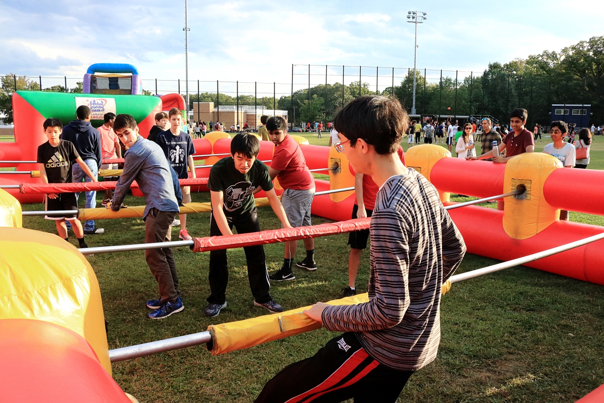 Students play human foosball in the baseball field.