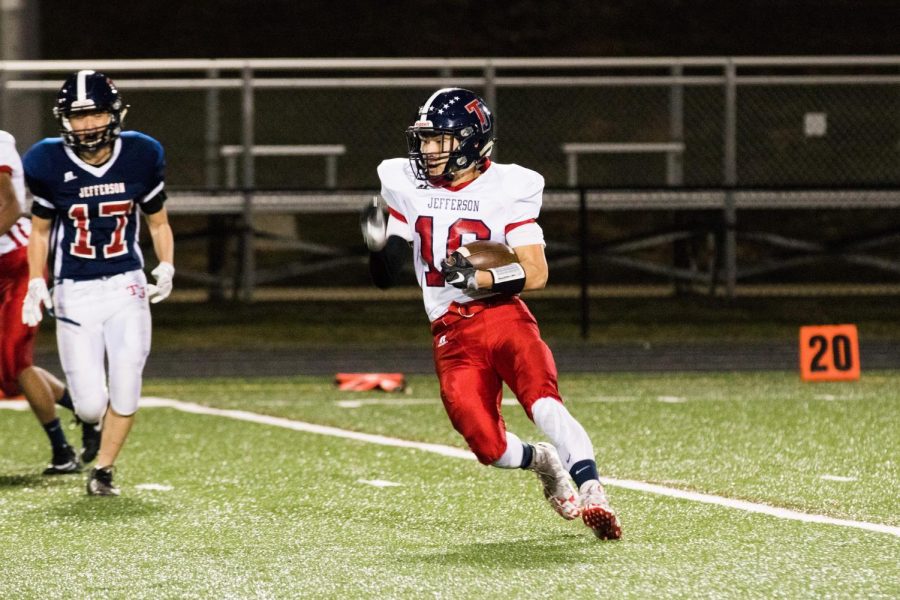 Junior Justin Kim makes a dash for the end zone, ball tucked in tightly under his arm, looking for a touchdown.