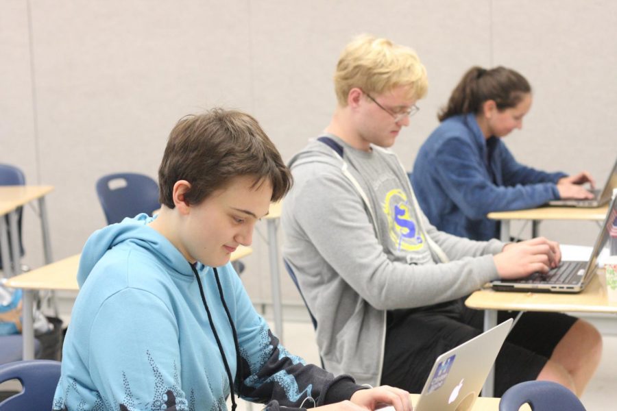 Junior Madeline Old and senior Jack McLaughlan draft a story on their laptops during Threshold and Skiffy's writing event.