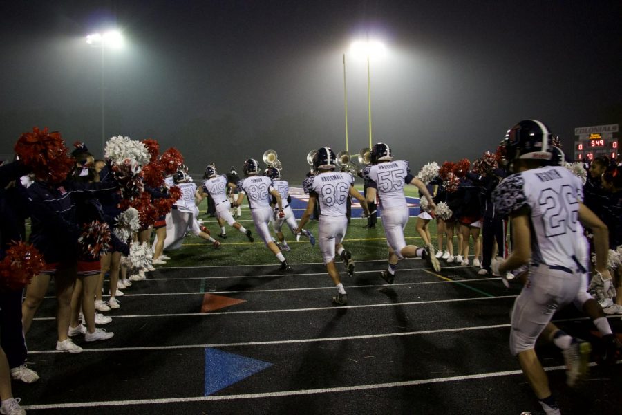 Jefferson's cheerleaders and Marching Band welcome the varsity football team as they run out to the field.