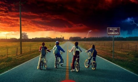 Mike (Finn Wolfhard), Dustin (Gaten Matarazzo), Lucas (Caleb McLaughlin), and Will (Noah Schnapp) look out over the horizon to confront the latest threat to Hawkins, Indiana.  Hawkins exists just near a parallel universe known as the Upside Down, from where monsters crawl into the town.