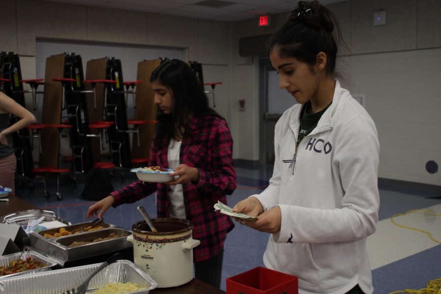 Junior Rhea Nandra checks payments. Nandra is a part of junior Nandhana Nair's group, which sold pasta with a variety of toppings.