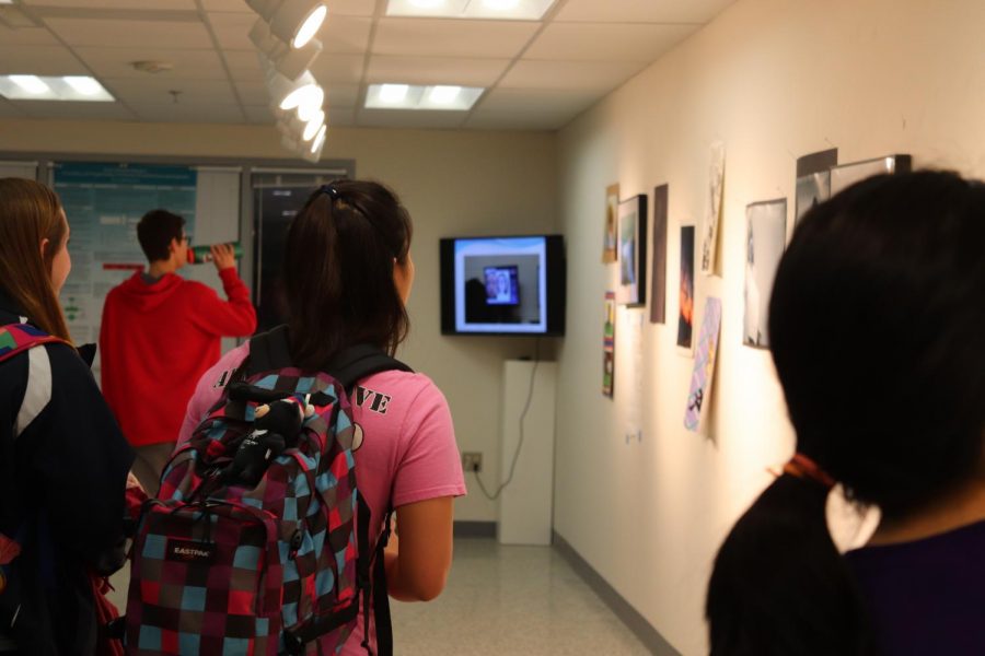 Students walk through the gallery.