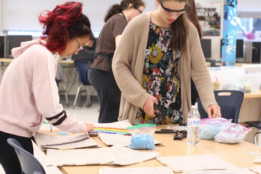 Sophomores and Art Club members Victoria Yang and Grace Cullen arrange glass tiles for the mosaic project. The club works on the project during weekly eighth period meetings. 