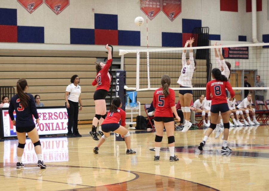 Senior Jenny Pruitt jumps to hit the ball back to Justice players.