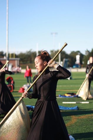 Junior Vicky Yang, a color guard captain, practicing right before the homecoming game performance. In the past months leading up to the homecoming football game, color guard put in a lot of effort in order to throw a splendid performance. They started practices along with hornline two weeks before school even started so that they could learn and perfect their techniques.