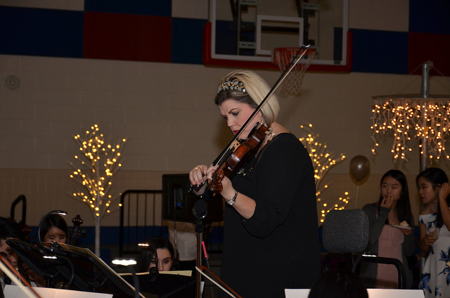 Ms. Bailey, the orchestra director, leads the Symphonic Orchestra in a waltz during the ball. Photo courtesy of Daniel S. Cha.