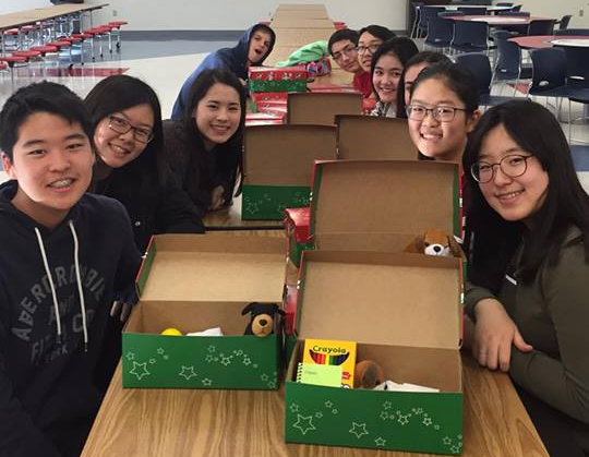 Members of Fellowship of Christians package gifts into shoeboxes to be shipped to children in other countries.