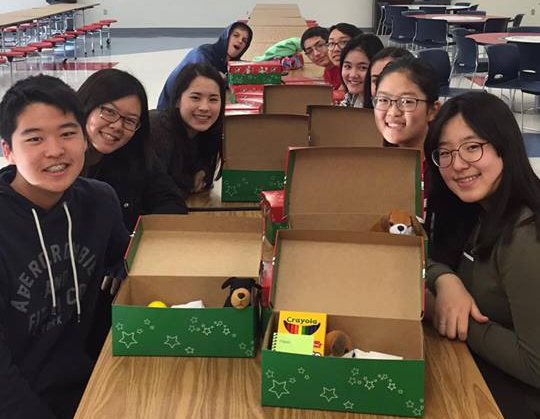 Members of Fellowship of Christians package gifts into shoeboxes to be shipped to children in other countries. 