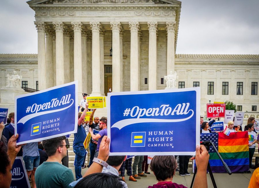 Protesters outside of the Supreme Court rally in favor of the same-sex couple alleging discrimination against a baker who cited his religion when refusing to make them a wedding cake.