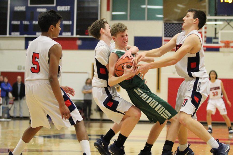 Jefferson players team up against a player on the other side to gain possession of the ball. Jefferson’s Men’s JV Basketball team faced off against the Falls Church team and ended with a loss by one point. “You're allowed to grab the ball as long as you don't reach over someone or reach with both arms around someone. In the picture, Ian is grabbing him[Falls Church player] from the back, that’s illegal,” sophomore Rakesh Pillai said.