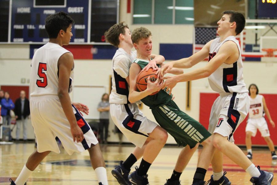 Jefferson players team up against a player on the other side to gain possession of the ball. Jefferson’s Men’s JV Basketball team faced off against the Falls Church team and ended with a loss by one point. “Youre allowed to grab the ball as long as you dont reach over someone or reach with both arms around someone. In the picture, Ian is grabbing him[Falls Church player] from the back, that’s illegal,” sophomore Rakesh Pillai said.