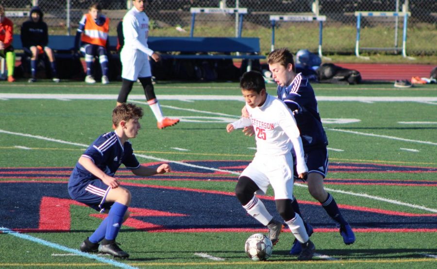 Dribbling+down+the+field+as+two+Woodson+defenders+attempt+to+steal+the+ball%2C+midfielder+Jason+Zhong+looks+to+pass+the+ball.+Off+to+a+slow+start%2C+the+Colonials+found+themselves+down+by+a+goal+in+the+first+half+but+managed+to+hustle+and+clinch+a+2-1+victory.