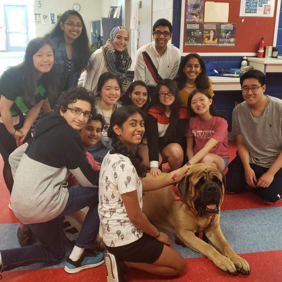 The tjTODAY staff pose with Jackson the therapy dog during one of his classroom visits during Stress Less Laugh More week.