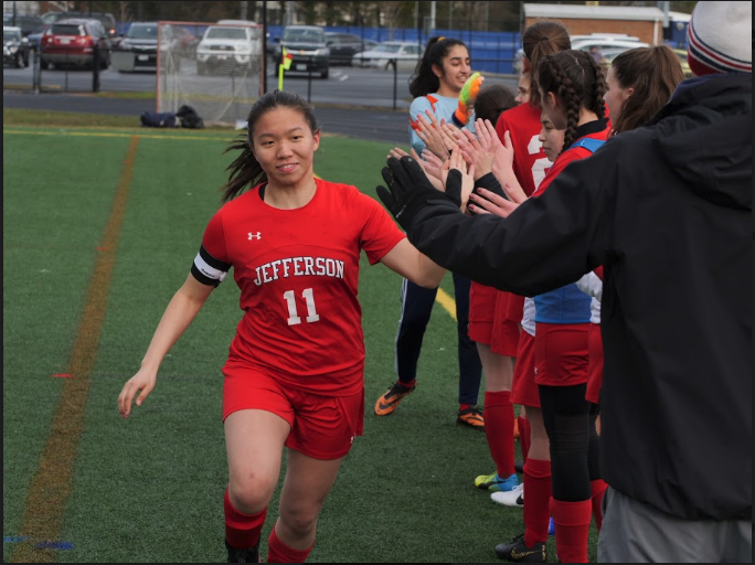 Player+Sherrie+Feng+high-fives+the+team+as+she+gets+ready+to+take+the+field+before+the+game.+Khushie+Matharoo%2C+typically+goalie%2C+stands+in+the+front+of+the+line.