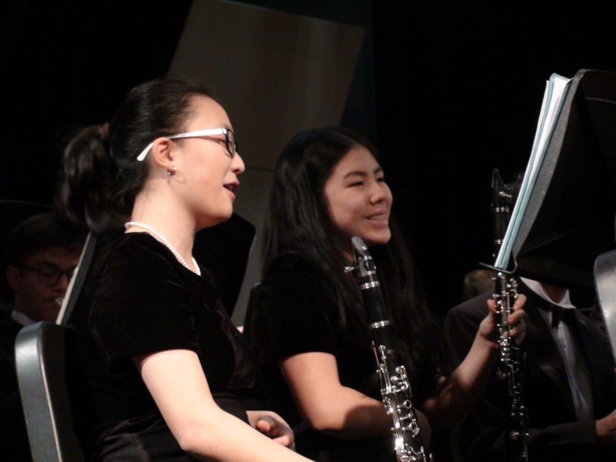 Laughing with her friend, freshmen and clarinet player, Mira Kim, enjoys her first high school band concert as part of the Symphonic Wind Ensemble. She performed at the fall concert on Oct. 23 at Jefferson. “Band is a significant part of how I handle my stress at TJ. I take band as a way to relax, rejuvenate, [and] just play music,” Kim said. 