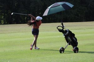 Senior Khushi Chawla swings her golf club, sending her ball flying on the green. To prepare for regionals, Chawla practiced twice on the course where regionals would be held (Laurel Hill Golf Club). "I mostly focused on the weaker aspects of my game, including putting, bunker shots and shots out of the rough," Chawla said.