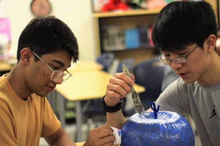 Sophomores Farhan Ayaan and Jinwoo Kim paint their pumpkin during Latin Honors Society’s Mythological Pumpkins event. “I enjoyed working with my friend and making an artistic work,” Kim said.
