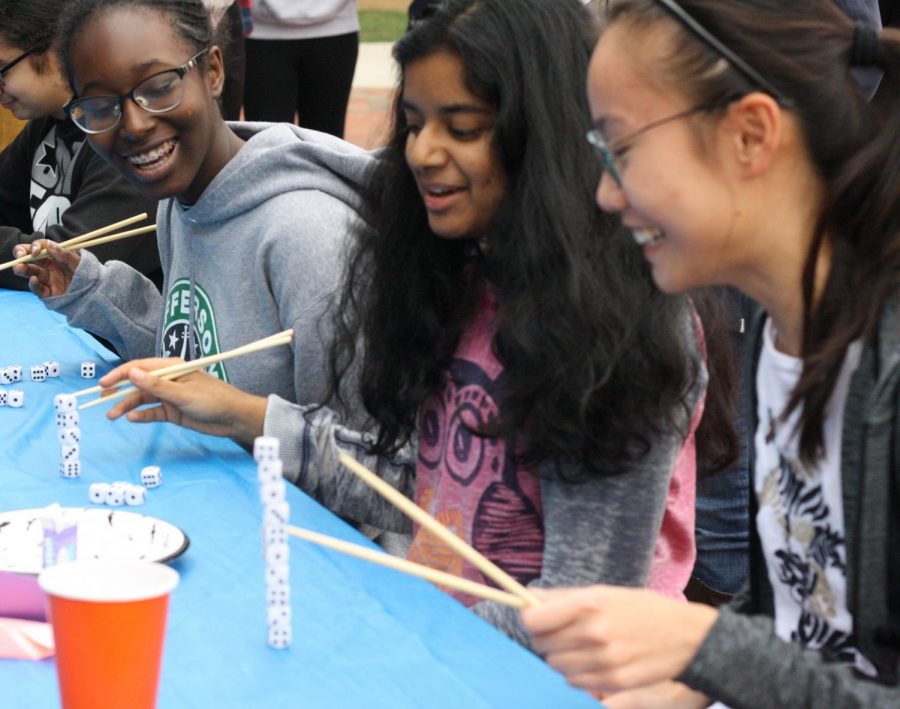 Sophomores Abena Kyereme-tuah (far left), Tanisha Pagadala and Natalie Wu laugh as the use chopsticks to stack dice on top of each other. “For me, it was nice that we were all able to go to the same eighth period and hang out and have fun,” Tanisha Pagadala said.