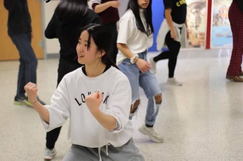 Senior Emily Wang shows a friend how to perform a dance in the choreography. Throughout 8th period, Urban Dance Movement (UDC) officers taught new members new dances for tryouts. 
