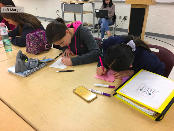 Freshman Jessica May and Ellie Chung work together to decorate the holiday cards. “I think it’s a really good opportunity and it’s really nice to be able to make cards for these kids in the hospitals during Christmas,” May said. 
