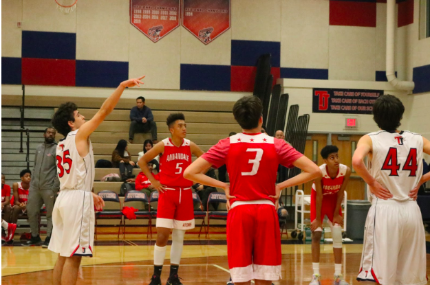 Point guard Franco Scartascinni takes the free throw as the players make a circle around the key. Scarascinni misses but the team is determined to maintain their lead.
