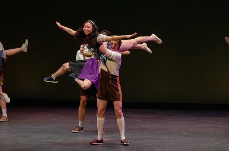 Arms held out, graduated senior Tiffany Zhang is twirled into the air.