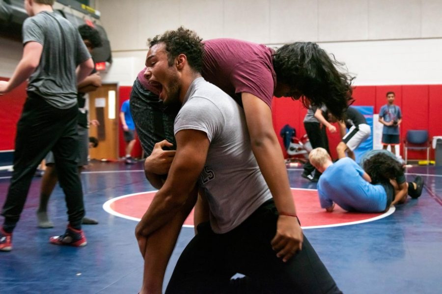 Roaring triumphantly, senior Caleb O'Cain suplexes freshman Rushil Umaretiya during a wrestling practice. 