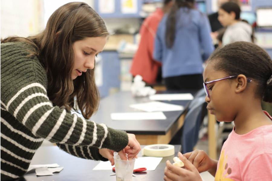 A 4th grader at Weyanoke Elementary school listens as freshman Megan Enochs explains the science behind constructing a safe and secure container for the egg drop. Enochs is part of a WISE, in which Jefferson students teach girls from Weyanoke Elementary School about scientific concepts through fun experiments. 