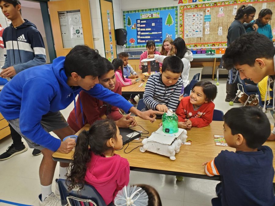 Freshman+Rusheel+Nadipally+and+freshman+Dhruv+Khatod+demonstrate+circuits+and+electrical+components+to+eager+elementary+school+students.