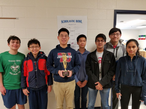 Following their victory at the regional scholastic bowl, the Quiz Bowl Team smiles with their trophy