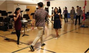 As junior Jenaly Dizon gives instructions, junior Niko Economos and freshman Priya Ray demonstrate for attendees 