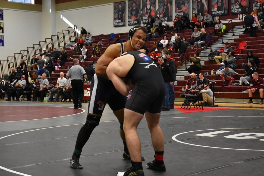 Grabbing his opponent in a headlock, senior Caleb OCain competes at wrestling states.