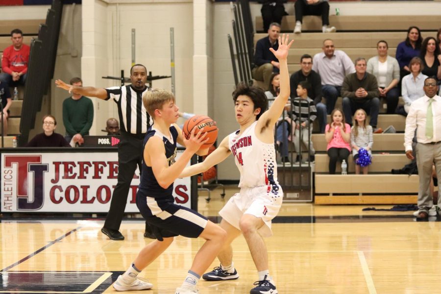 Putting his hand out to block a shot, senior Samuel Kim defends against his opponent. The Varsity Men’s Basketball team competed against the Trinity School at Meadowview on Friday night. “I was forcing the ball to the right to my help defender. We call the defense ‘21’ and it's a 1-3-1 concept,” Huang said.