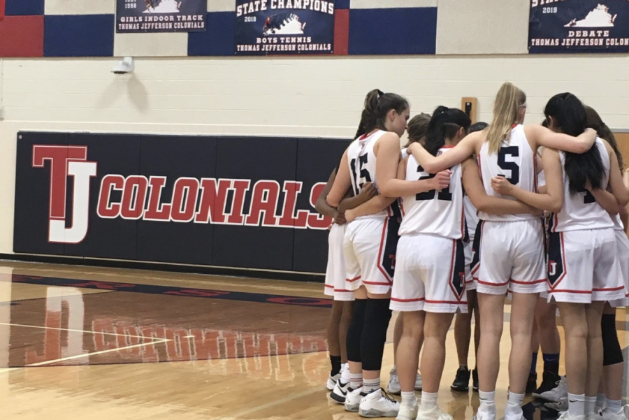 The Jefferson varsity girls basketball team huddled together after a time-out. 