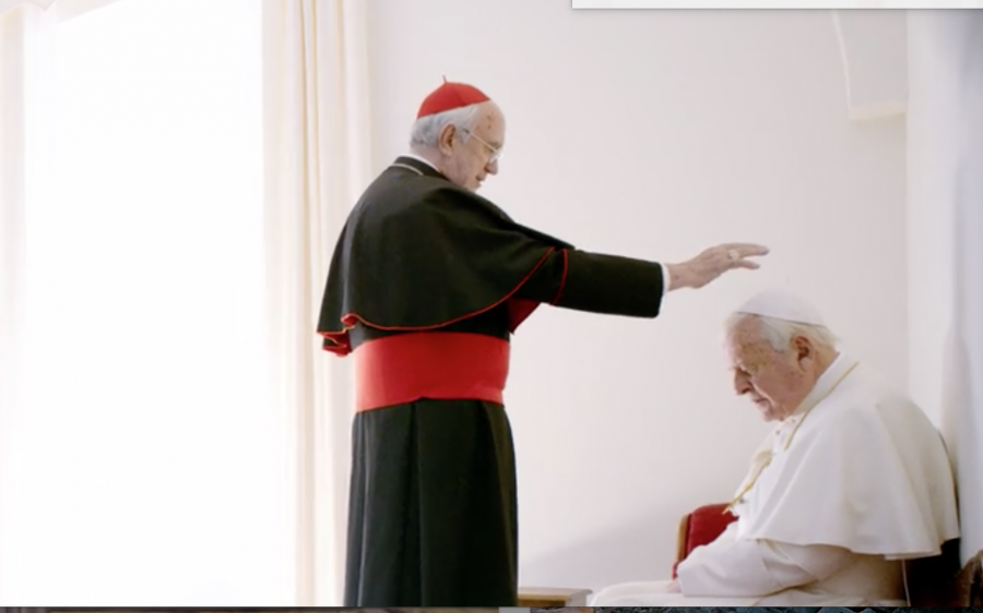Cardinale Bergoglio (Jonathan Pryce) stands before a kneeling Pope Benedict (Anthony Hopkins) after the Pope Benedict offered him his title of "Pope". The scene took place in a smaller replica of the Sistine Chapel created for the movie.