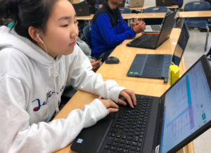 Freshman Yulee Kang listens to music as she completes her work in class.

