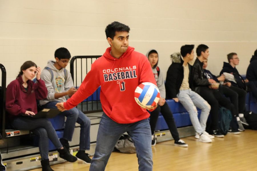 Arm held back, senior Saketh Gabbita prepares to serve the ball