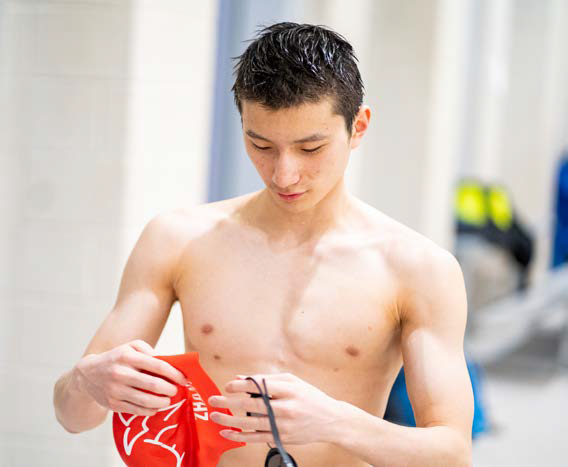 Preparing for his race, sophomore Michael Zhang puts his cap on his head