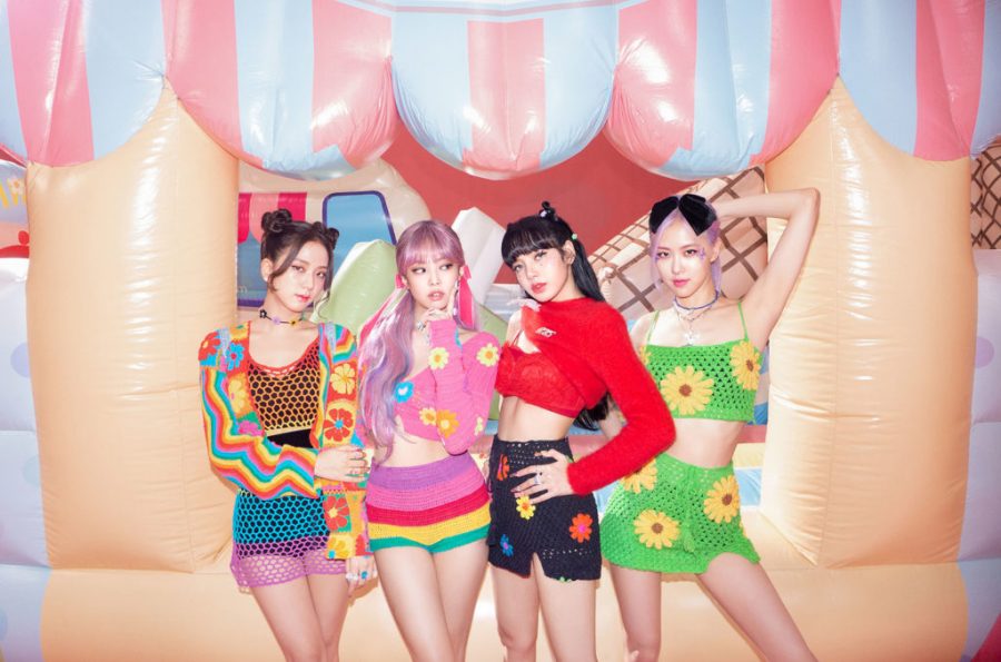 Blackpink poses in front of a bouncy house in a promotional image for “The Album.” From left to right are the members, Jisoo, Jennie, Lisa, and Rosé.