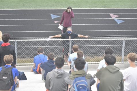 Coaches make announcements at the beginning of a track and field practice. “We want to make sure people’s families are safe,” sophomore Aidan Singer said. “The mask mandate will help with that.”