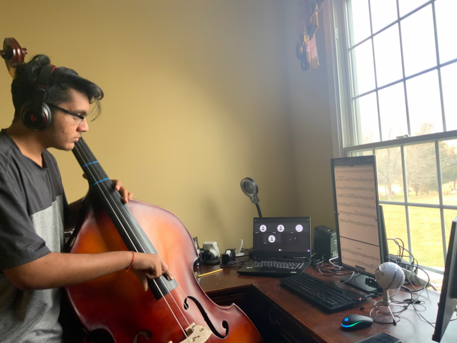 With his eyes on digital sheet music, sophomore Rushil Umaretiya practices during an online strings class