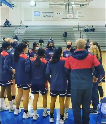 The girls Varsity Basketball Team celebrates together during an earlier win against the Lee Lancers.