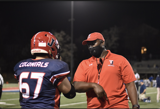 Offensive lineman Oliver Tu (67) receives advice from offensive line coordinator Enoch Boateng.