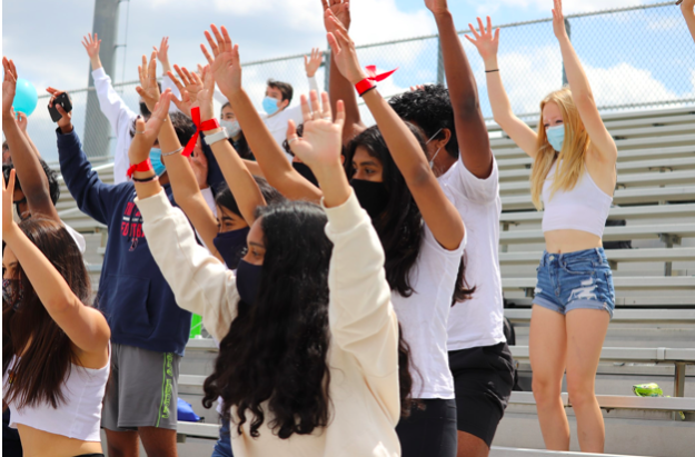 Students in the Class of 2023 cheer from the stands during one of TJ’s 2021 pep rallies. At the pep rally, students upheld the tradition of wearing their signature class color. 