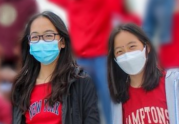 From left to right, Lindsay and Ashley Hwang smile amongst their classmates on the freshmen bleacher stands during a homecoming pep rally. “I love hanging out with Lindsay, especially when we’re at a big event or something; it’s really nice to have someone I know I can count on,” A. Hwang said.