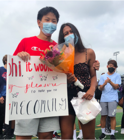 Sophomores Tommy Fan and Abhi Periyasamy pose for a photo with sophomore Ella Kim’s handmade Chick-fi-la themed homecoming poster after a successful asking. “People needed posters, and I was the man,” Kim said. 
