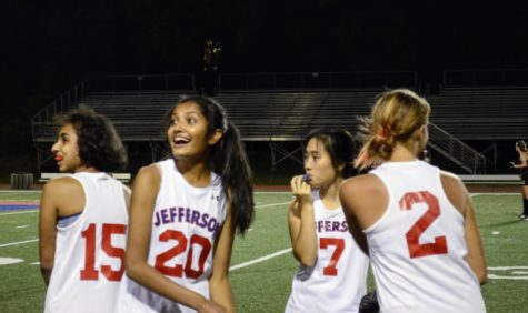 As the scoreboard changes from 0 to 1, Samhitha Singiresu (20) looks over with her fellow teammates, smiling.