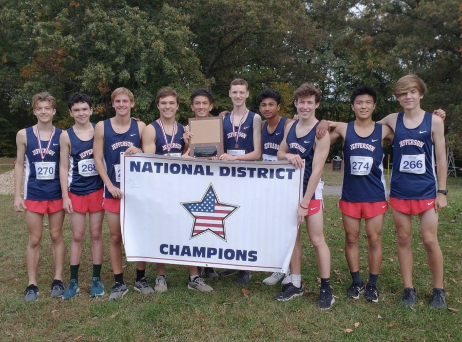 The Jefferson boys' cross country team holds the district championship banner. "As a sophomore, I ran in the district meet in 2020 when we won, and am very happy and satisfied that we have won again this year, now with me as a senior," senior Jeremy West said. 